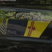 The logo is visible as the hearse leaves Balmoral. Picture: BBC