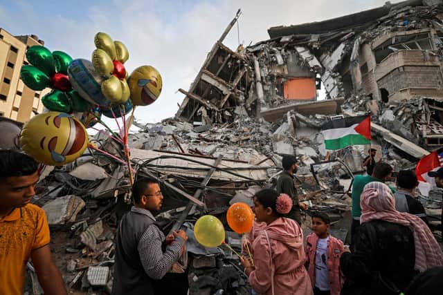 A man sells balloons in front of a building destroyed by an Israeli airstrike in Gaza City (Picture: Mahmud Hams/AFP via Getty Images)