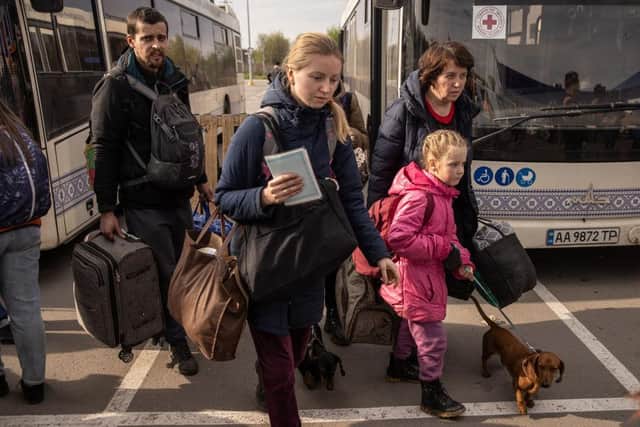 People disembark an evacuation bus after arriving at an evacuation point for people fleeing the Azovstal plant, Mariupol, Melitopol and the surrounding towns under Russian control in Zaporizhzhia, Ukraine. Picture: Getty Images