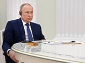 Russian President Vladimir Putin listens to French President Emmanuel Macron during their meeting in the Kremlin