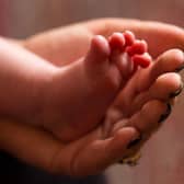 A mother holds the feet of a new baby. More babies have been admitted to hospital with the Omicron variant. Picture: PA