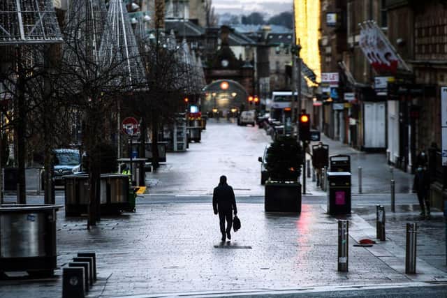 Pedestrians walk through central Glasgow as Scotland imposes a nationwide coronavirus lockdown for the rest of January (Photo by ANDY BUCHANAN/AFP via Getty Images)
