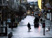 Pedestrians walk through central Glasgow as Scotland imposes a nationwide coronavirus lockdown for the rest of January (Photo by ANDY BUCHANAN/AFP via Getty Images)