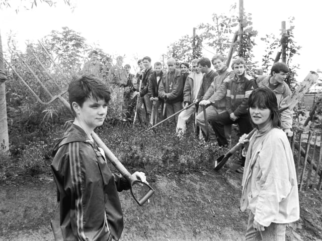 A group of teenagers on the Youth Training Scheme (YTS) with spades and forks at the Glasgow Garden Festival site in August 1987.