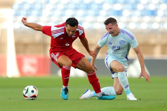 Kenny McLean of Scotland is challenged by Jack Sergeant of Gibraltar.