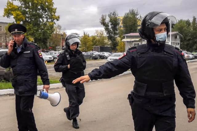 Police officers guard as students evacuate a building of the Perm university campus.