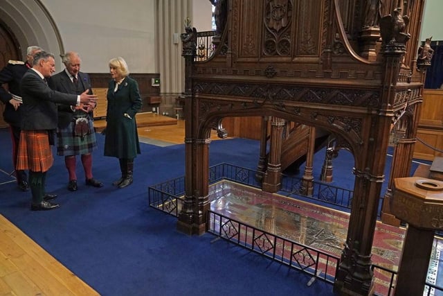 King Charles III and the Queen Consort are shown the grave stone of Robert the Bruce during a visit to Dunfermline Abbey