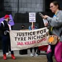 Protesters hold signs during a rally against the fatal police assault of Tyre Nichols.
