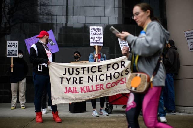Protesters hold signs during a rally against the fatal police assault of Tyre Nichols.
