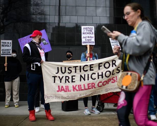 Protesters hold signs during a rally against the fatal police assault of Tyre Nichols.