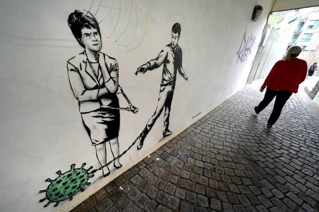 A new piece of street art by The Rebel Bear has appeared on a wall in Cannongate, Edinburgh, showing First Minister Nicola Sturgeon with a pair of bolt cutters alongside a person pulling a germ by a chain.