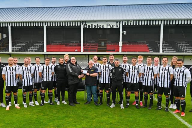 ​Fraserburgh FC chairman, Finlay Noble, hands over the cheque to Broch RNLI coxswain, Vic Sutherland.