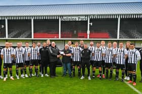 ​Fraserburgh FC chairman, Finlay Noble, hands over the cheque to Broch RNLI coxswain, Vic Sutherland.