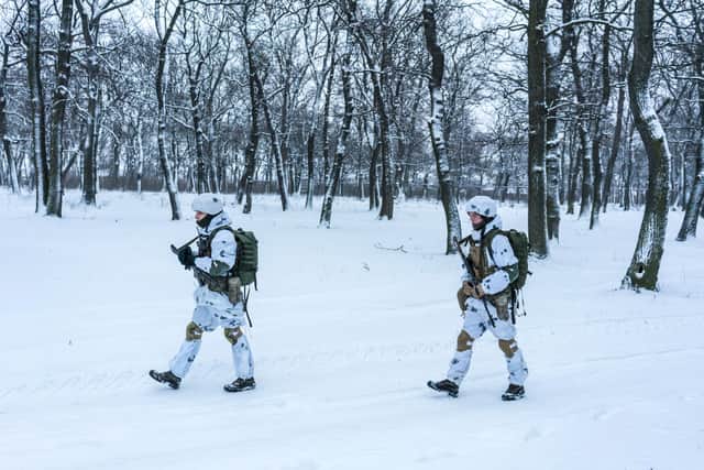 CHASIV YAR, UKRAINE - JANUARY 19: Ukrainian soldiers walk through a snowy park on January 19, 2022 in Chasiv Yar, Ukraine. Photo by Brendan Hoffman/Getty Images