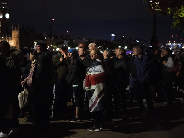 Members of the public in the queue at 03:47 on the Thames Path opposite the Palace of Westminster in London, as they wait to view Queen Elizabeth II lying in state ahead of her funeral on Monday. Picture date: Friday September 16, 2022.