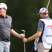 Bob MacIntyre takes his putter from  caddie Mike Thomson in the Hero Cup singles session at Abu Dhabi Golf Club. Picture: Andrew Redington/Getty Images.