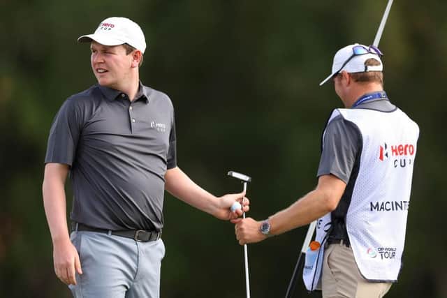 Bob MacIntyre takes his putter from  caddie Mike Thomson in the Hero Cup singles session at Abu Dhabi Golf Club. Picture: Andrew Redington/Getty Images.