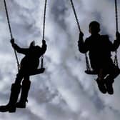 Children enjoying playing on swings in a park.
