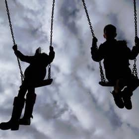 Children enjoying playing on swings in a park.