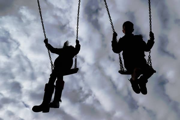 Children enjoying playing on swings in a park.