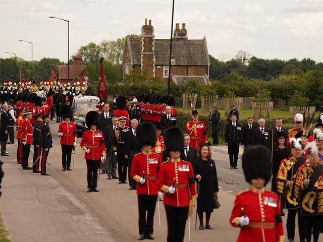 The State Hearse carrying the coffin of Queen Elizabeth II, draped in the Royal Standard with the Imperial State Crown and the Sovereign's Orb and Sceptre, drives along Albert Road, Windsor, on its journey from the State Funeral at Westminster Abbey, London, to a Committal Service at St George's Chapel in Windsor Castle, Berkshire. Picture date: Monday September 19, 2022.