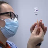 A member of the vaccine team prepares a syringe with a dose of the AstraZeneca/Oxford Covid-19 vaccine