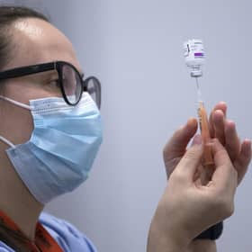 A member of the vaccine team prepares a syringe with a dose of the AstraZeneca/Oxford Covid-19 vaccine