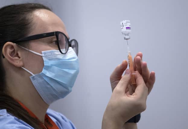 A member of the vaccine team prepares a syringe with a dose of the AstraZeneca/Oxford Covid-19 vaccine