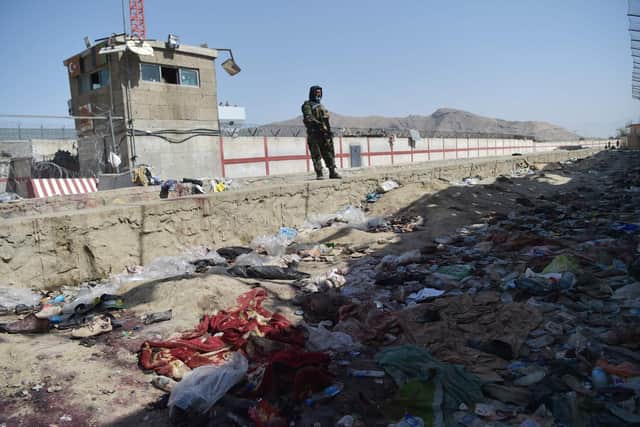 A Taliban fighter stands guard at the site of two powerful explosions, which killed scores of people including 13 US troops on August 26, at Kabul airport on August 27, 2021. (Image credit: Wakil Kohsar/AFP via Getty Images