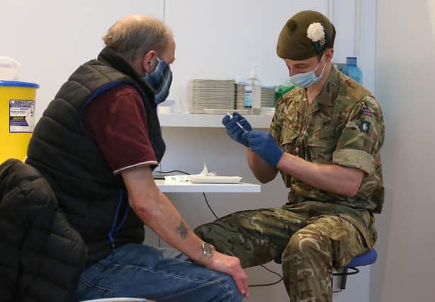 Military doctor Captain Robert Reid prepares to administer a Covid-19 vaccine to Edinburgh resident Derek Fraser at a temporary vaccination centre set up at the Royal Highland Showground (Picture: Andrew Milligan/pool/AFP via Getty Images)