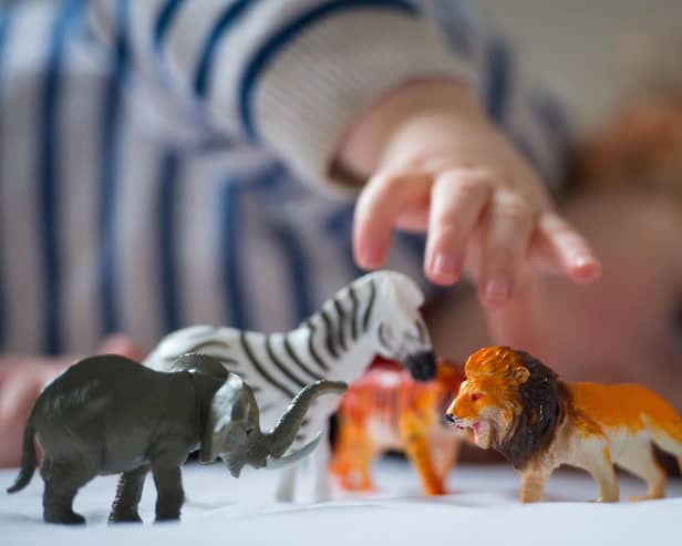 A preschool age child playing with plastic toy animals. Dominic Lipinski/PA Wire