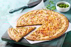 A gluten free pizza with bacon and spring onion.