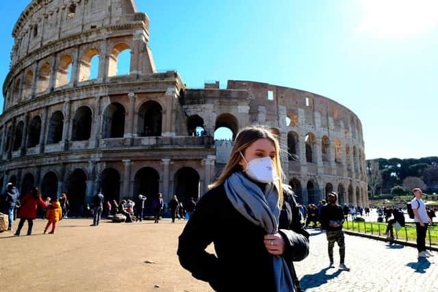 A tourist wearing a protective respiratory mask outside the Coliseum in downtown Rome (Photo: ANDREAS SOLARO/AFP via Getty Images)