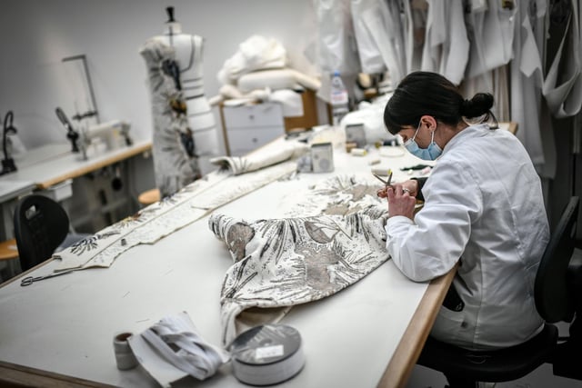 A seamstress works on a couture garment at Christian Dior's Haute Couture fashion house
