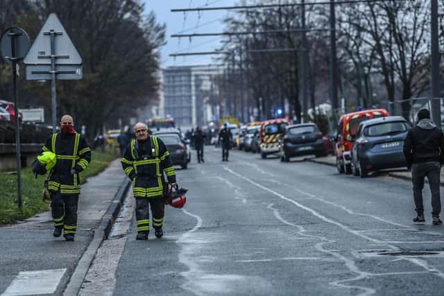 Firefighters walk in the Mas-Du-Taureau neighbourhood  where a fire caused many victims, in Vaulx-en-Velin, east of Lyon, south-eastern France, on December 16, 2022. -