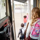 Pupils leave the bus on their way to primary school