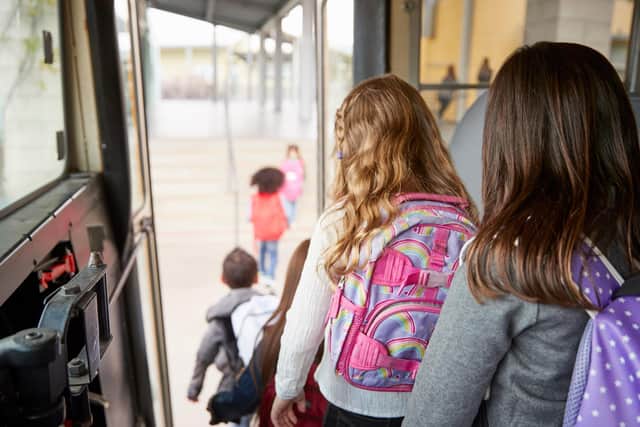 Pupils leave the bus on their way to primary school