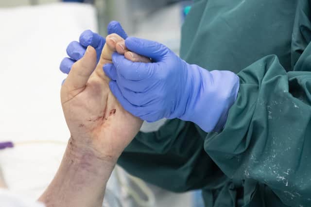 A nurse holds the hand of a Covid patient in intensive care (Picture: Alessandra Tarantino/AP)