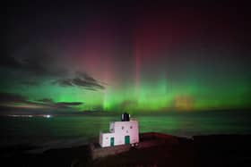 The aurora borealis, also known as the northern lights, appears over Bamburgh Lighthouse, in Northumberland on the north east coast of England. Picture: Owen Humphreys/PA Wire