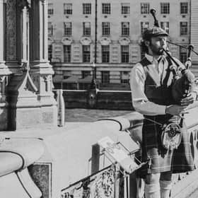 “A bagpiper performs on Westminster Bridge, echoing the enduring global appeal of Scottish musical traditions now influencing digital licensing trends.”