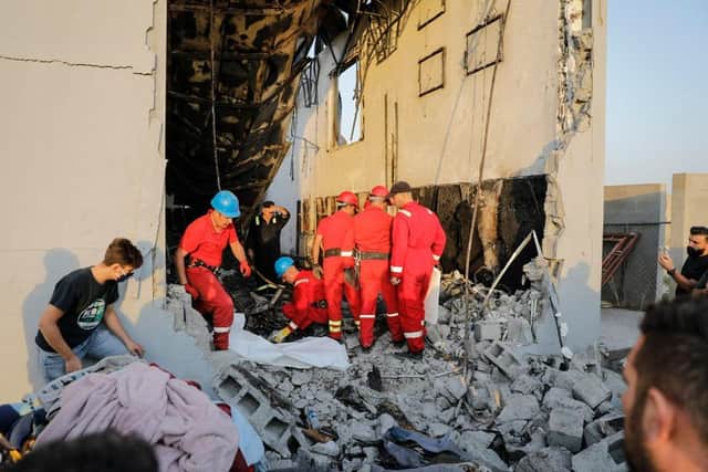Firefighters check the damage in an event hall in Qaraqosh, also known as Hamdaniyah, after a fire broke out during a wedding, killing at least 100 people and injuring more than 150.