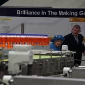 Queen Elizabeth II with Chief Executive Roger White in the bottling plant during a visit to AG Barr's factory in Cumbernauld.