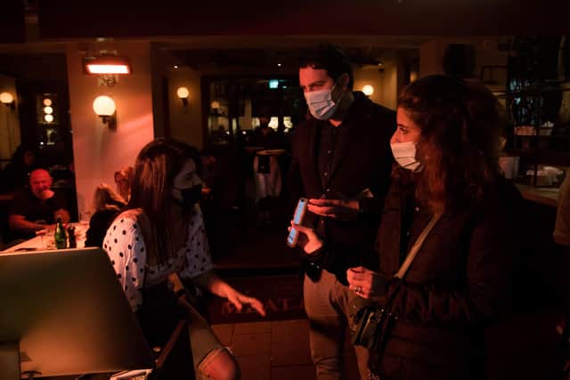 A couple present a 'Green Pass' vaccination certificate to staff at a bar in Tel Aviv, Israel, where a controversial Covid passport system has been introduced (Picture: Amir Levy/Getty Images)