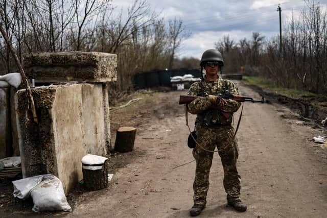 A Ukrainian serviceman stands guard at a checkpoint on the outskirts of Barvinkove, eastern Ukraine.