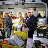 Pictured: Simon McMahon (Amazon) Gordon Brown, and  Pauline Buchan from the Cottage Family Centre at the warehouse which sits at the heart of the vast 'click and collect' project (Pic: Ian Georgeson)