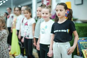 Refugees living in temporary accommodation, like these girls who are housed on a cruise ship in Edinburgh, have started moving into refurbished social housing in Wishaw.