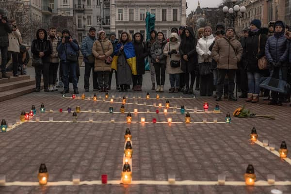 People gather in Kyiv next to candles that are put in order to depict the word 'Children' during a memorial event on the anniversary of the Mariupol Theater Airstrike. Picture: Roman Pilipey/Getty Images