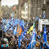 Pro-independence activists wave Scottish Saltire flags as they march from Holyrood to the Meadows in Edinburgh