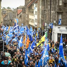 Pro-independence activists wave Scottish Saltire flags as they march from Holyrood to the Meadows in Edinburgh