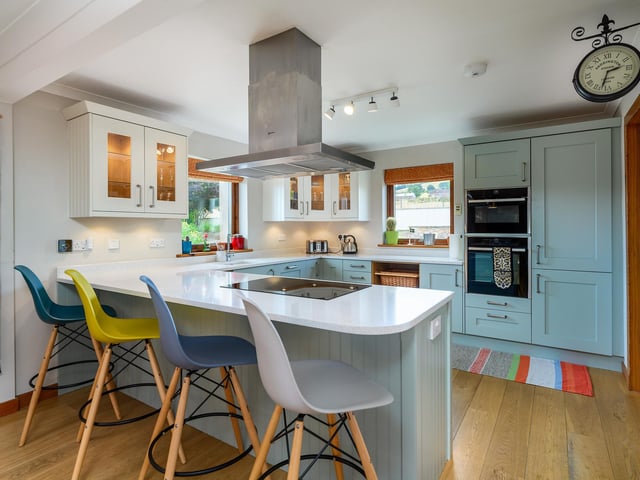 Interior: Its entrance hall features a welcoming stove and leads to an open-plan kitchen and dining room. The bay-windowed living room has doors opening to a terrace. Four bedrooms are spread over two floors.